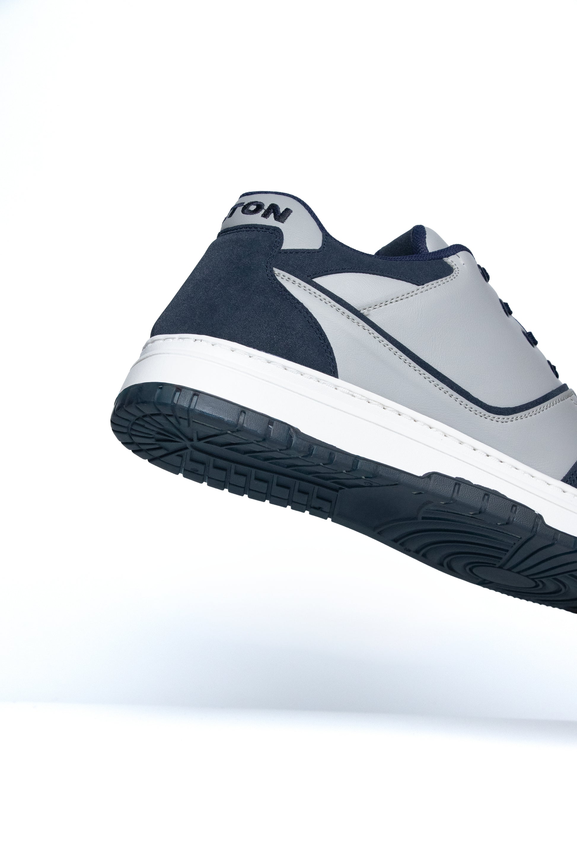 Navy and gray sneaker with white sole on a white background