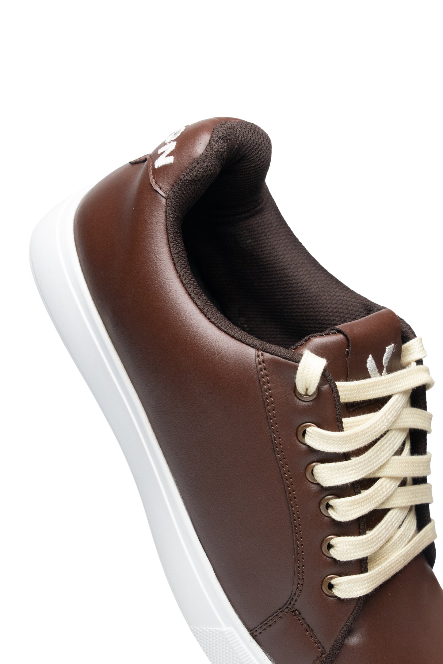 Brown leather sneaker with white laces on a white background
